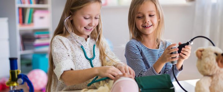 two young girls playing with medical equipment and toys